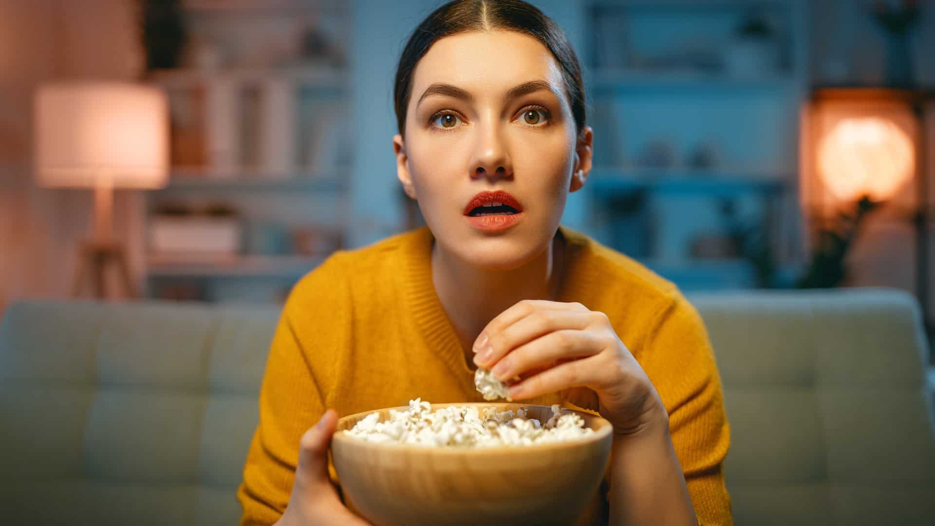 Woman watching movie and eating popcorn